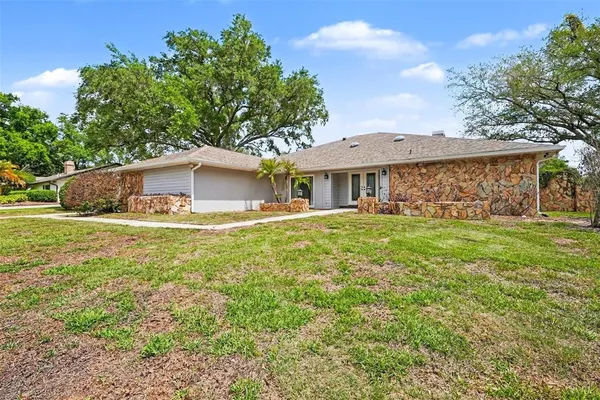 a view of house with yard and trees in the background