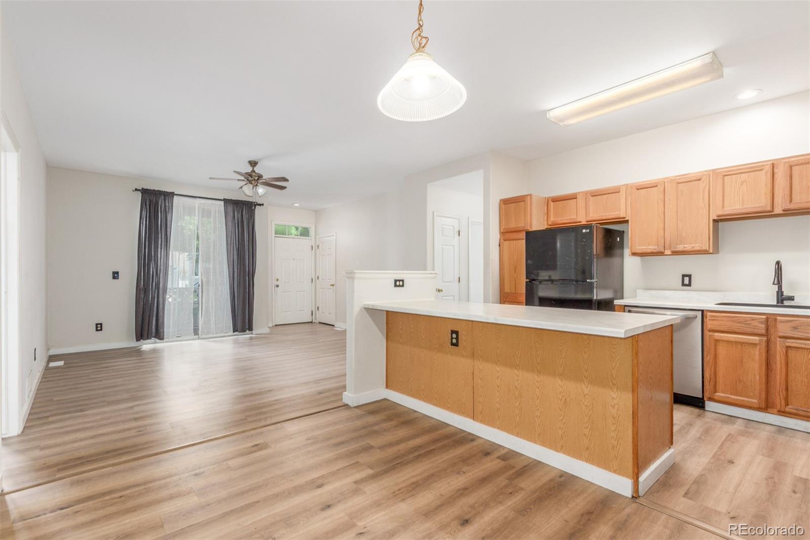12931 Lafayette Street, Unit G Thornton, CO 80241 - Photo 11 of 21 a large kitchen with cabinets and wooden floor