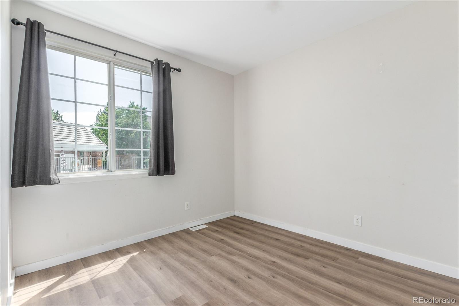 12931 Lafayette Street, Unit G Thornton, CO 80241 - Photo 14 of 21 an empty room with wooden floor and windows