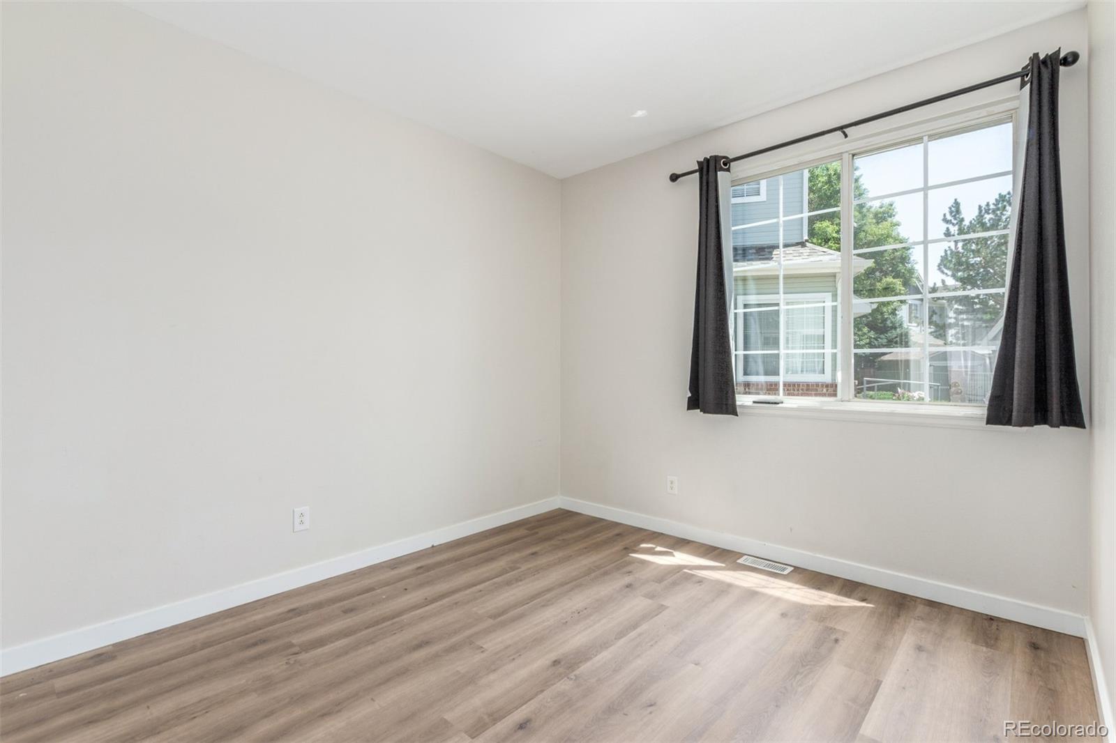 12931 Lafayette Street, Unit G Thornton, CO 80241 - Photo 15 of 21 wooden floor in an empty room with a window