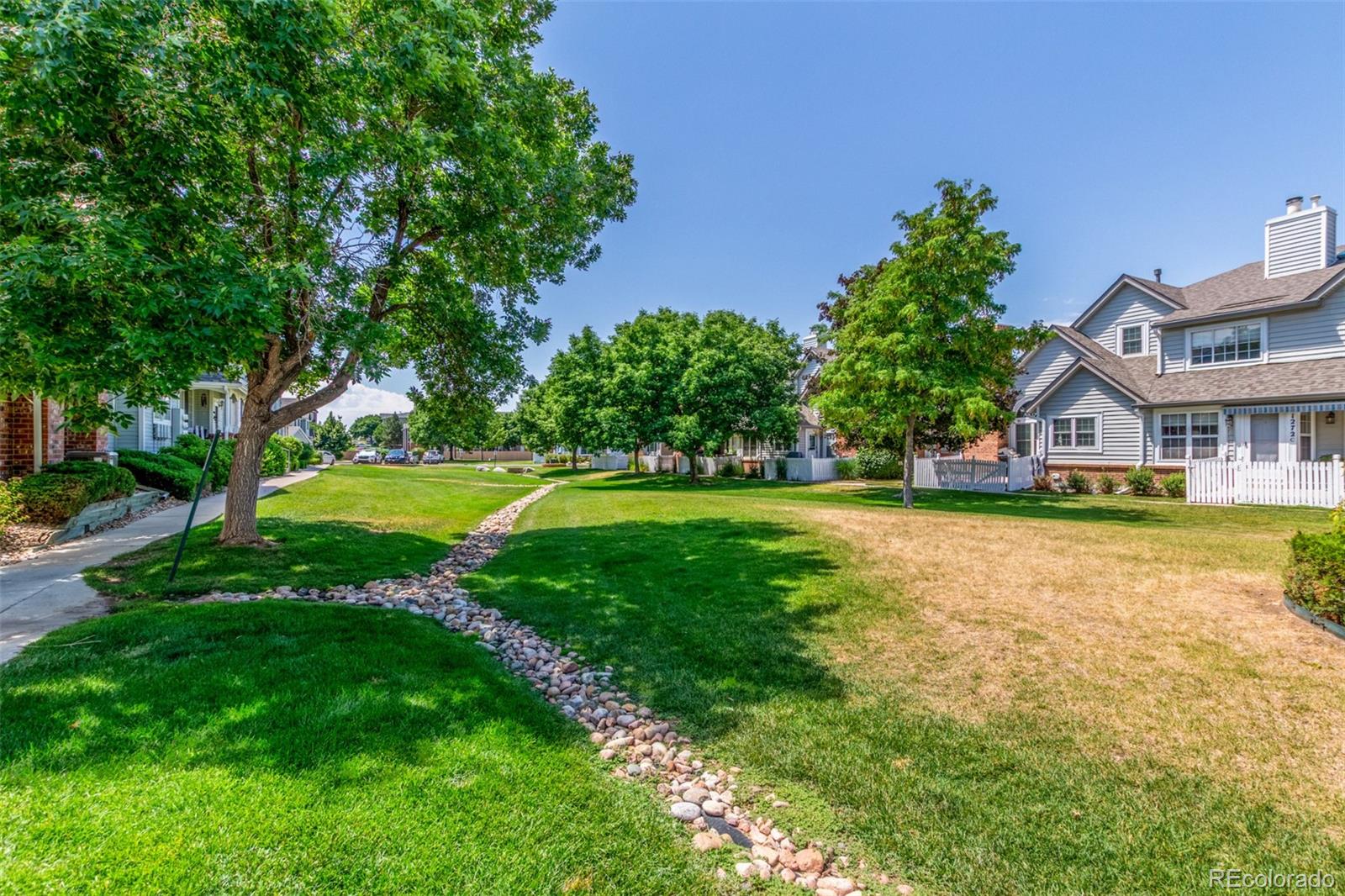 12931 Lafayette Street, Unit G Thornton, CO 80241 - Photo 19 of 21 a view of swimming pool with lawn chairs and large trees