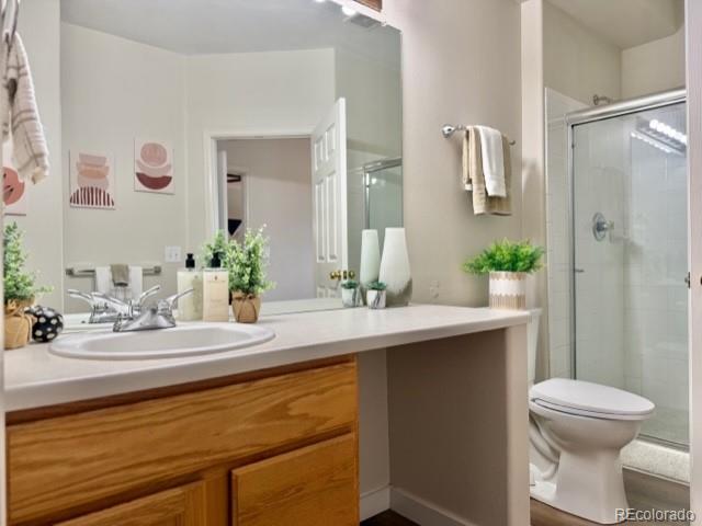 12931 Lafayette Street, Unit G Thornton, CO 80241 - Photo 9 of 21 a bathroom with a sink and mirror with toilet
