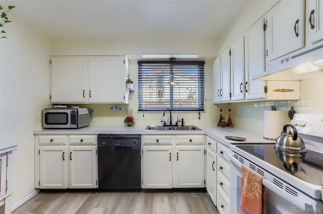a kitchen with cabinets appliances a sink and a window