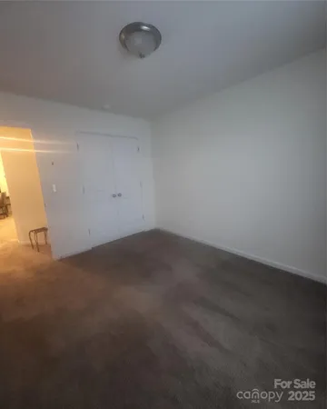 a view of a room that has wooden floor and cabinets