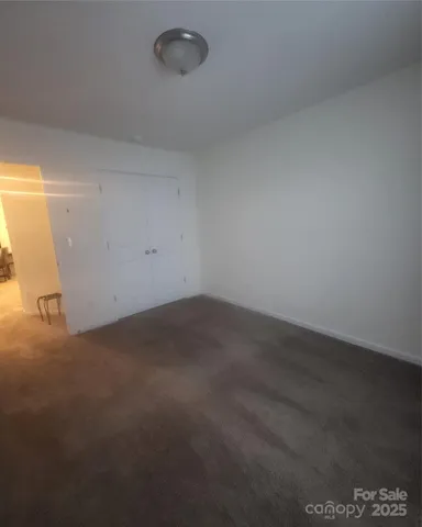 a view of a room that has wooden floor and cabinets