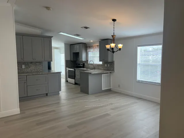 a view of kitchen with granite countertop microwave and stove top oven