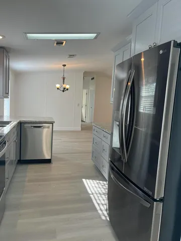 a kitchen with stainless steel appliances granite countertop a refrigerator and a stove