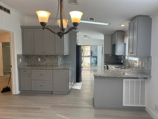 a kitchen with stainless steel appliances granite countertop a sink stove and cabinets