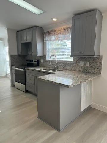 a living room with kitchen island furniture and a chandelier