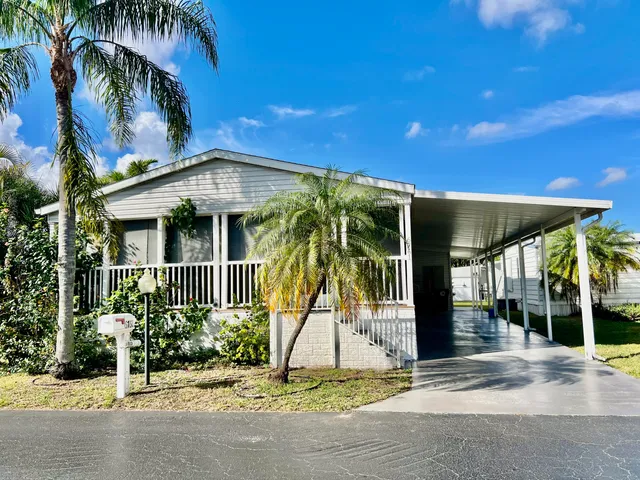 front view of house with a yard and potted plants