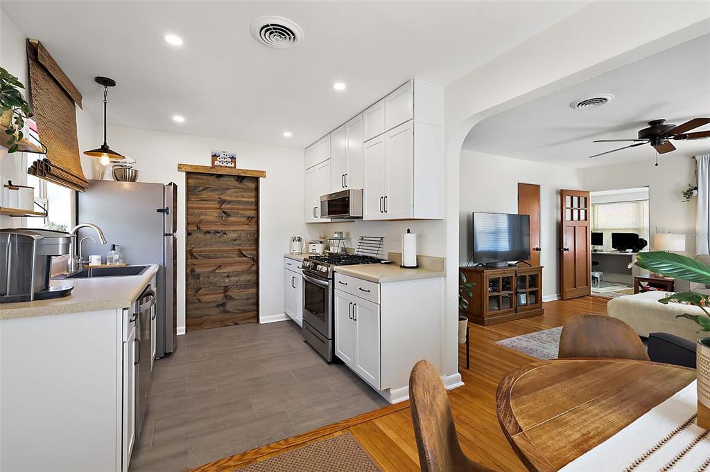 30 East Key Avenue Eustis, FL 32726 - Photo 9 of 32 a kitchen with stainless steel appliances kitchen island granite countertop a refrigerator oven a sink dishwasher and a stove with wooden floor