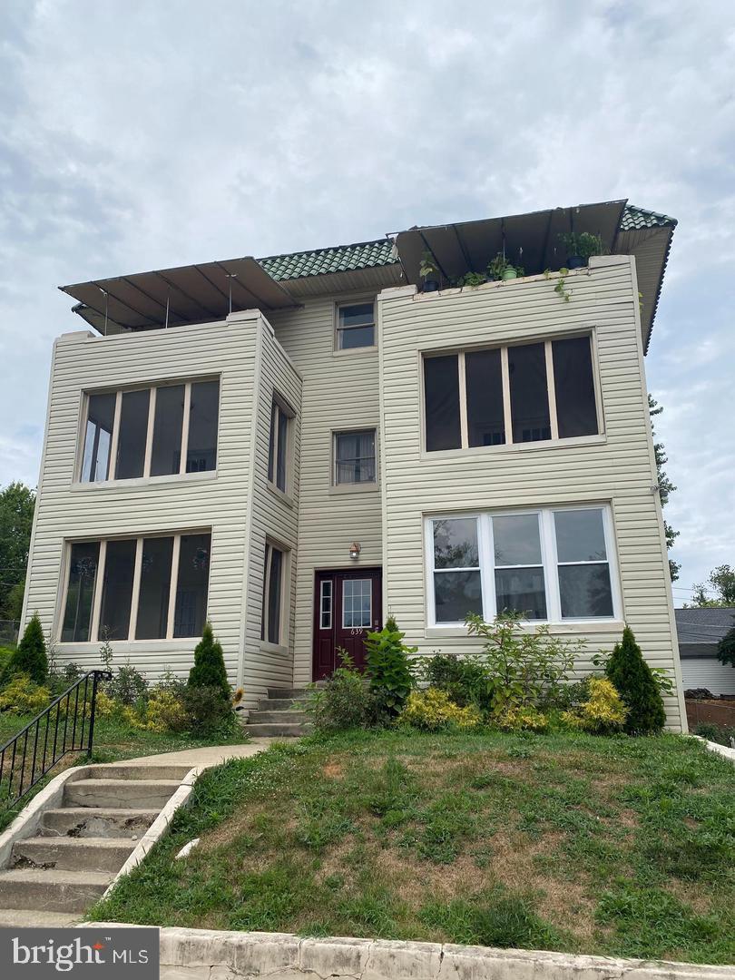 639 Plymouth Road, Unit A2 Baltimore, MD 21229 - Photo 1 of 14 a front view of a house with a yard