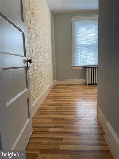 639 Plymouth Road, Unit A2 Baltimore, MD 21229 - Photo 4 of 14 a view of an empty room with wooden floor and a window