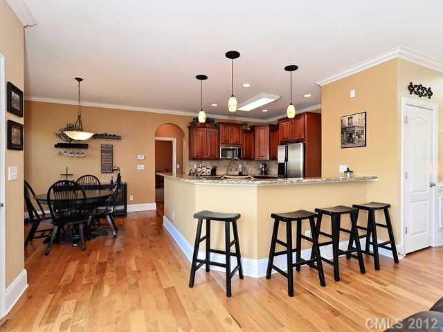512 St Ives Court Fort Mill, SC 29708 - Photo 4 of 16 a kitchen with stainless steel appliances kitchen island granite countertop a table chairs sink and cabinets