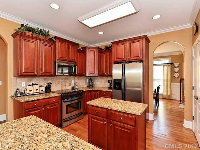 512 St Ives Court Fort Mill, SC 29708 - Photo 5 of 16 a kitchen with stainless steel appliances granite countertop a refrigerator a sink dishwasher a stove with wooden cabinets and floor