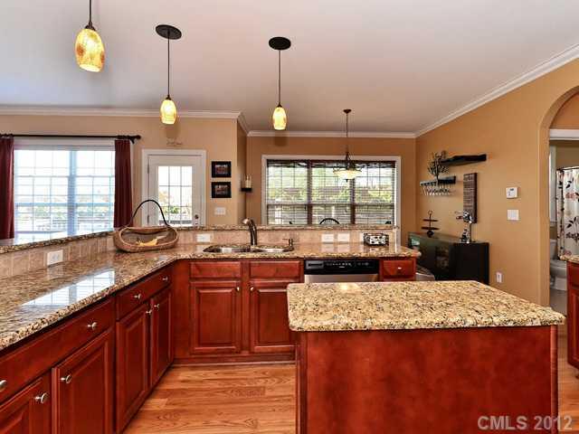 512 St Ives Court Fort Mill, SC 29708 - Photo 6 of 16 a kitchen with kitchen island granite countertop wooden cabinets and a sink