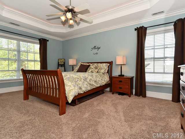 512 St Ives Court Fort Mill, SC 29708 - Photo 9 of 16 a spacious bedroom with a bed and a chandelier
