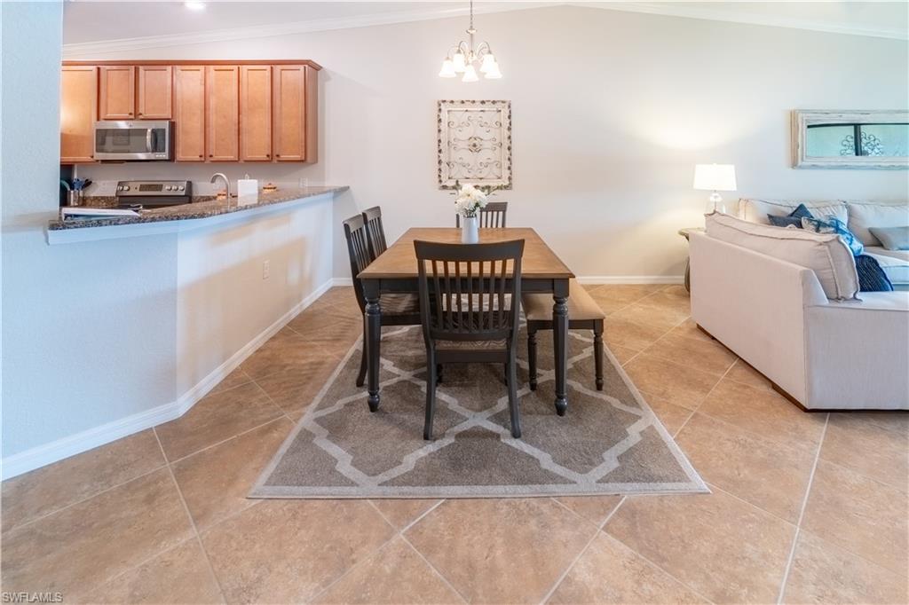 9521 Avellino Way, Unit 2426 Naples, FL 34113 - Photo 15 of 46 a dining room with furniture and a chandelier
