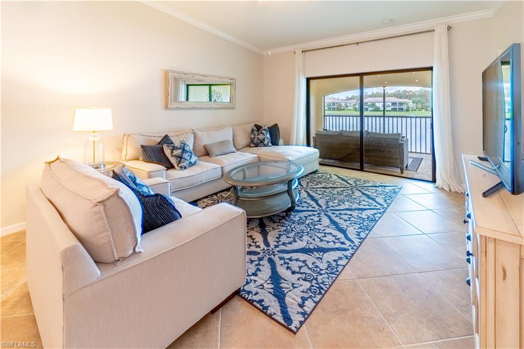 9521 Avellino Way, Unit 2426 Naples, FL 34113 - Photo 17 of 46 a living room with furniture and a floor to ceiling window
