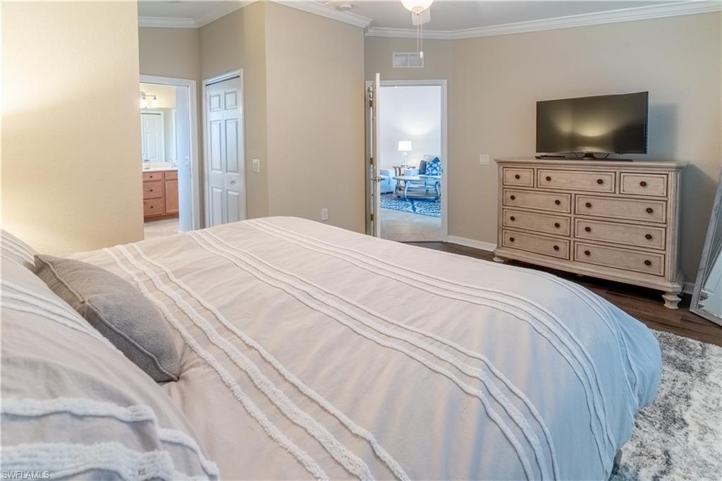 9521 Avellino Way, Unit 2426 Naples, FL 34113 - Photo 21 of 46 a bedroom with a bed and television