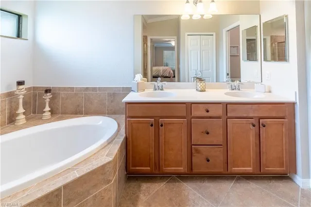 a bathroom with a tub sink and mirror