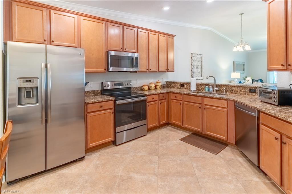 9521 Avellino Way, Unit 2426 Naples, FL 34113 - Photo 7 of 46 a kitchen with stainless steel appliances granite countertop a stove a sink dishwasher a refrigerator and a microwave