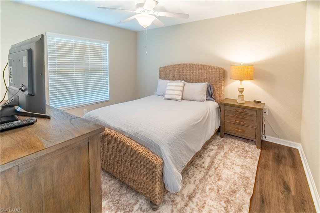 9521 Avellino Way, Unit 2426 Naples, FL 34113 - Photo 8 of 46 a bedroom with a bed and a night stand