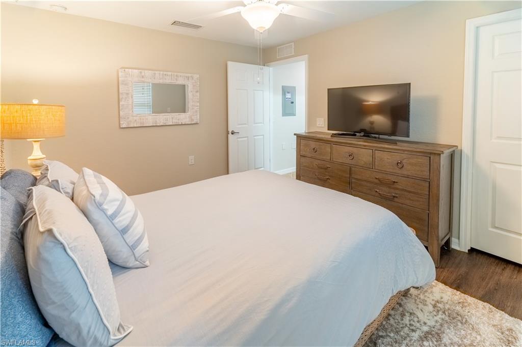 9521 Avellino Way, Unit 2426 Naples, FL 34113 - Photo 9 of 46 a bedroom with a bed and a flat screen tv