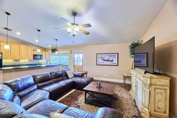 a living room with furniture ceiling fan and a flat screen tv