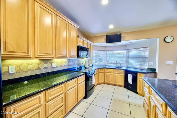 a view of a kitchen with stainless steel appliances granite countertop a sink and cabinets