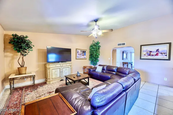 a living room with furniture a chandelier and a flat screen tv