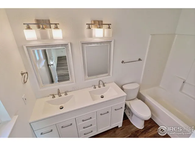 a bathroom with a double vanity sink toilet and mirror