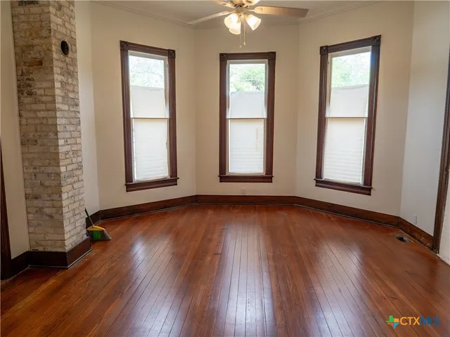 an empty room with wooden floor and entrance