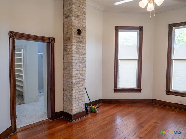 an empty room with wooden floor and entrance