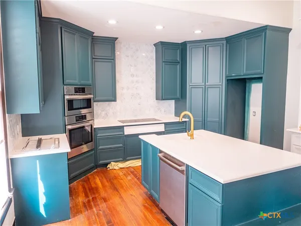 a kitchen with a sink cabinets and stainless steel appliances
