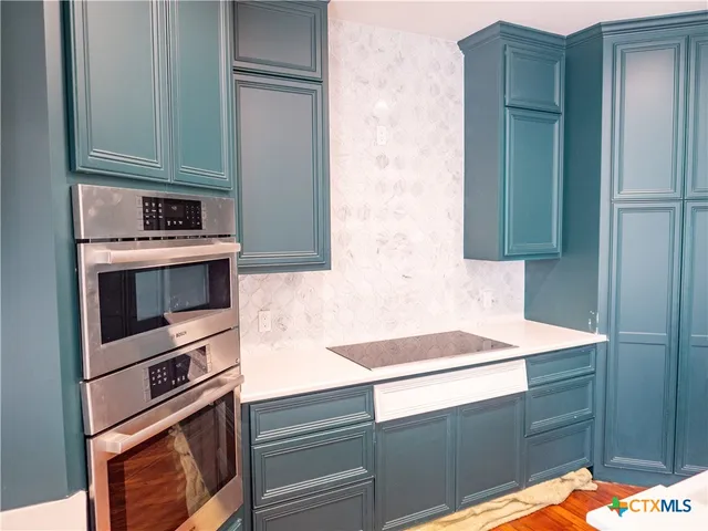 an empty room with wooden floor and a fireplace