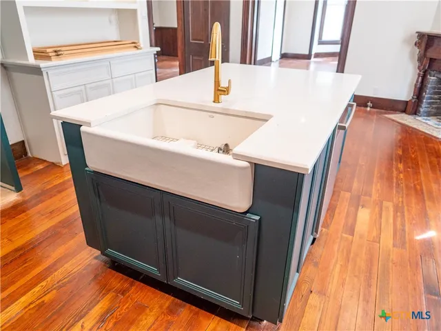 an empty room with wooden floor windows and two windows