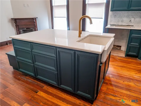 an empty room with wooden floor and a fireplace