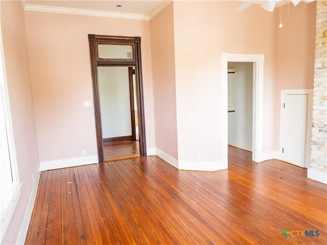 an empty room with wooden floor and a window