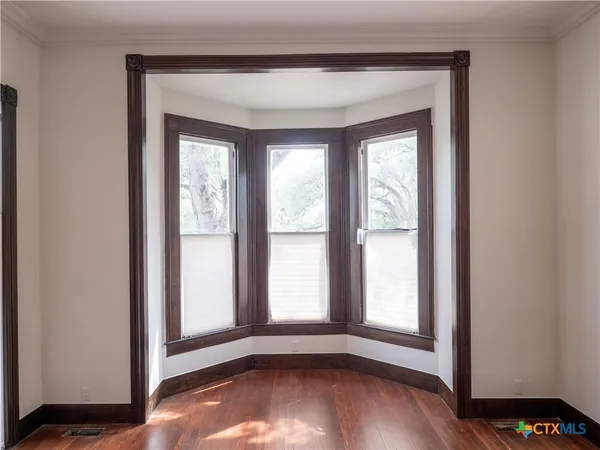 an empty room with wooden floor and a window
