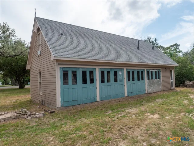 a front view of a house with a garden and trees