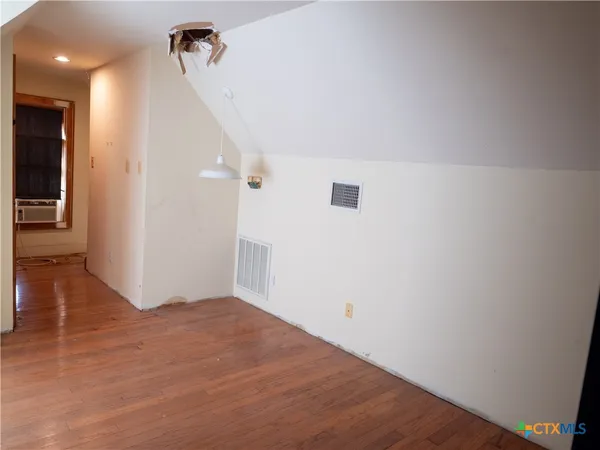a large white building with a big yard and large trees