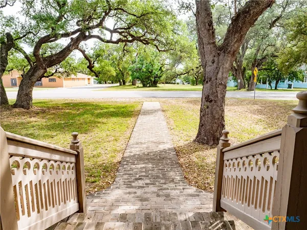 a view of a yard with wooden fence and a large tree