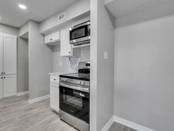 a kitchen with stainless steel appliances a stove and a microwave