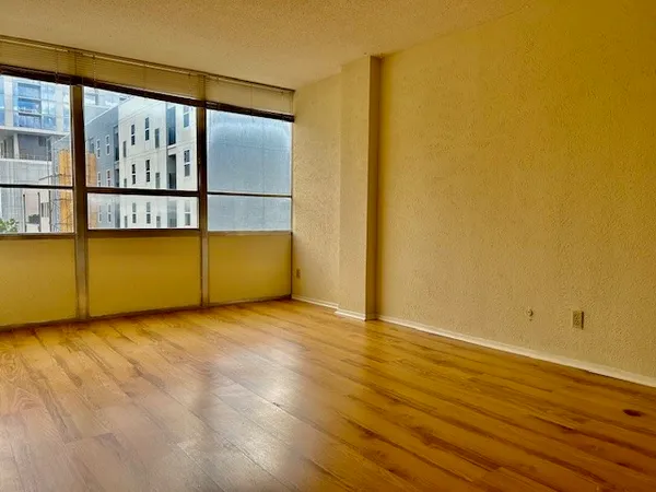 an empty room with wooden floor and a window