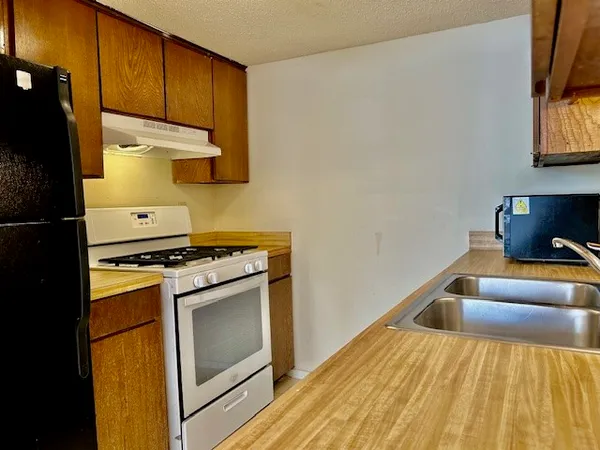a kitchen with stainless steel appliances granite countertop a stove and a sink