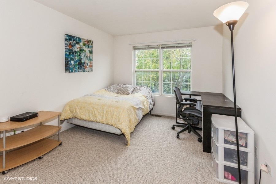 24099 Pear Tree Circle Plainfield, IL 60585 - Photo 12 of 17 a bedroom with a bed chair and a window