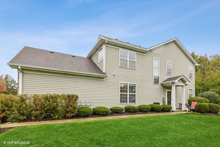 24099 Pear Tree Circle Plainfield, IL 60585 - Photo 15 of 17 a front view of a house with a garden and plants