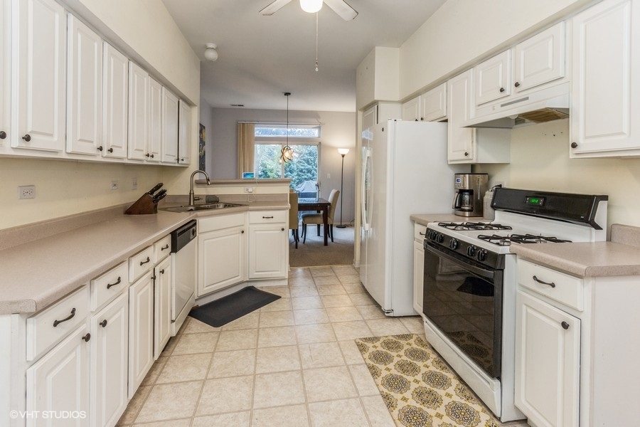 24099 Pear Tree Circle Plainfield, IL 60585 - Photo 4 of 17 a kitchen with white cabinets and appliances