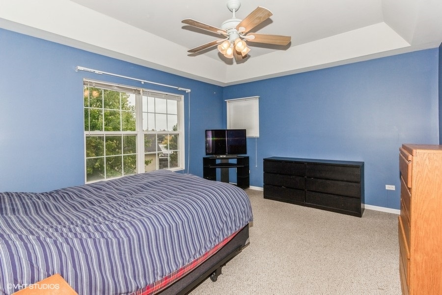 24099 Pear Tree Circle Plainfield, IL 60585 - Photo 10 of 17 a bedroom with a bed and a television